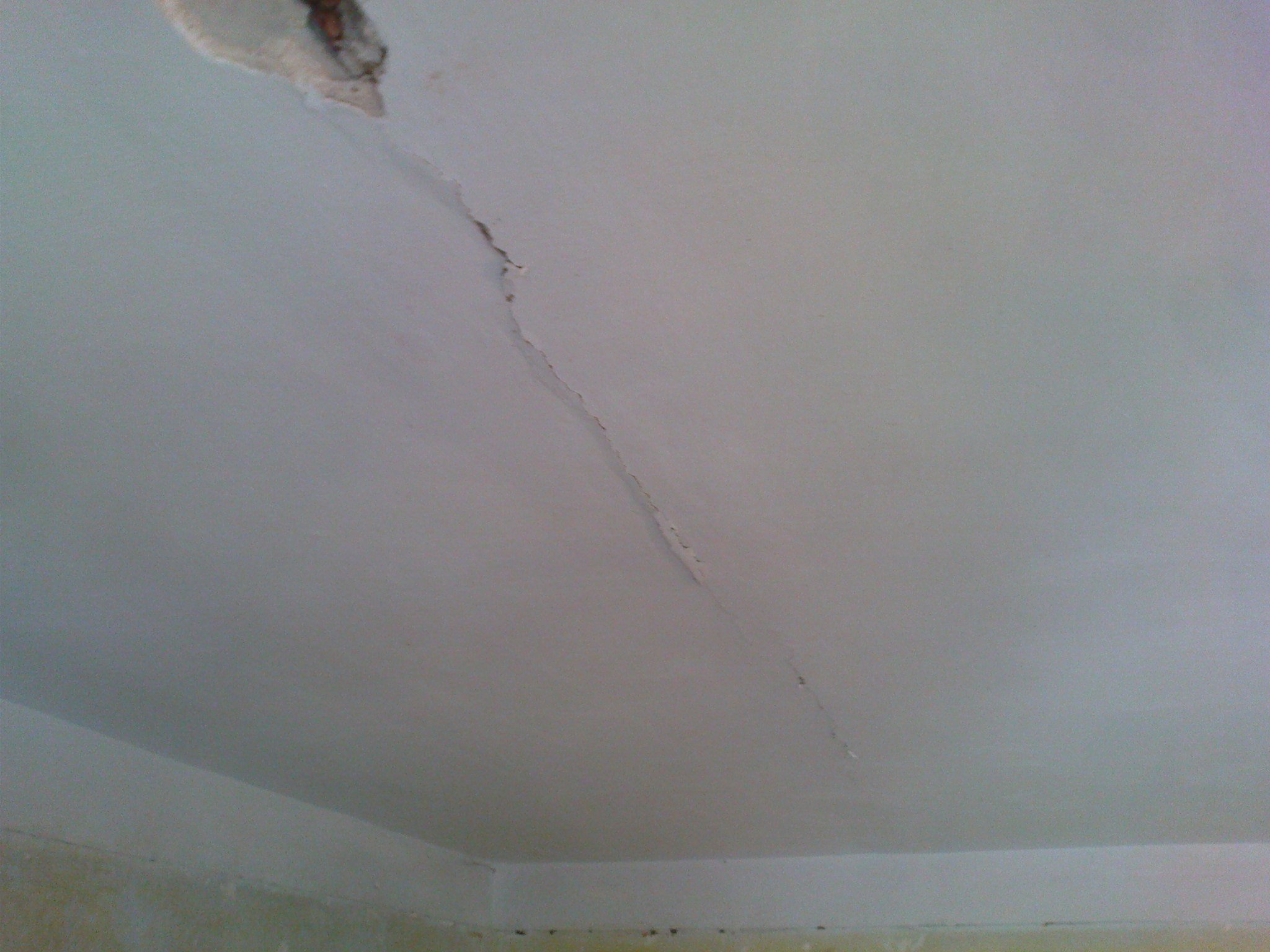 Что делать если появилась трещина. Трещины на потолке. Мелкие трещины на потолке. Микротрещины на потолке. На потолке трещины на стыке плит.