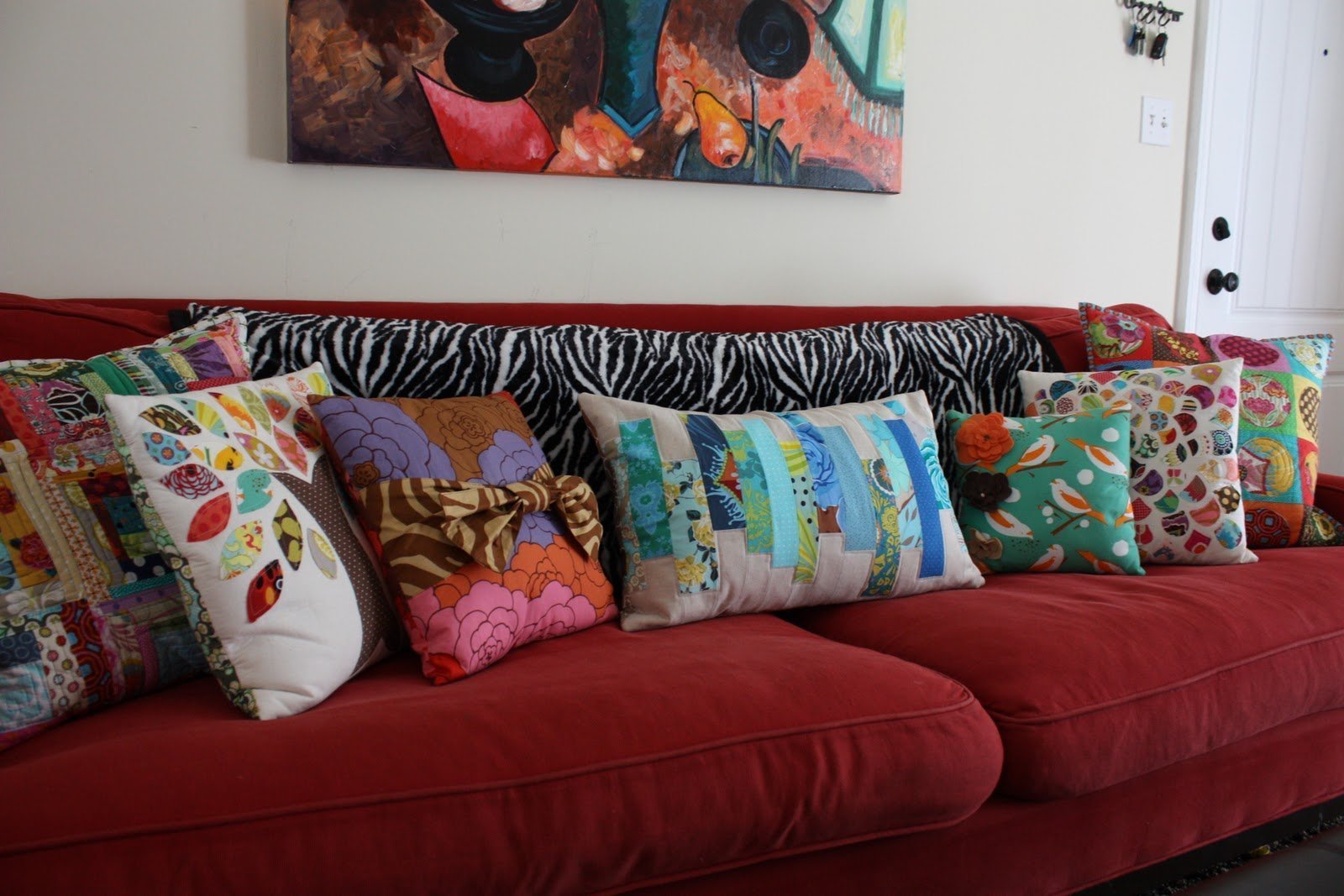 Фото дивана с подушками. Цветные подушки в интерьере. Подушка для дивана. Дизайнерские подушки для интерьера. Диван с яркими подушками.
