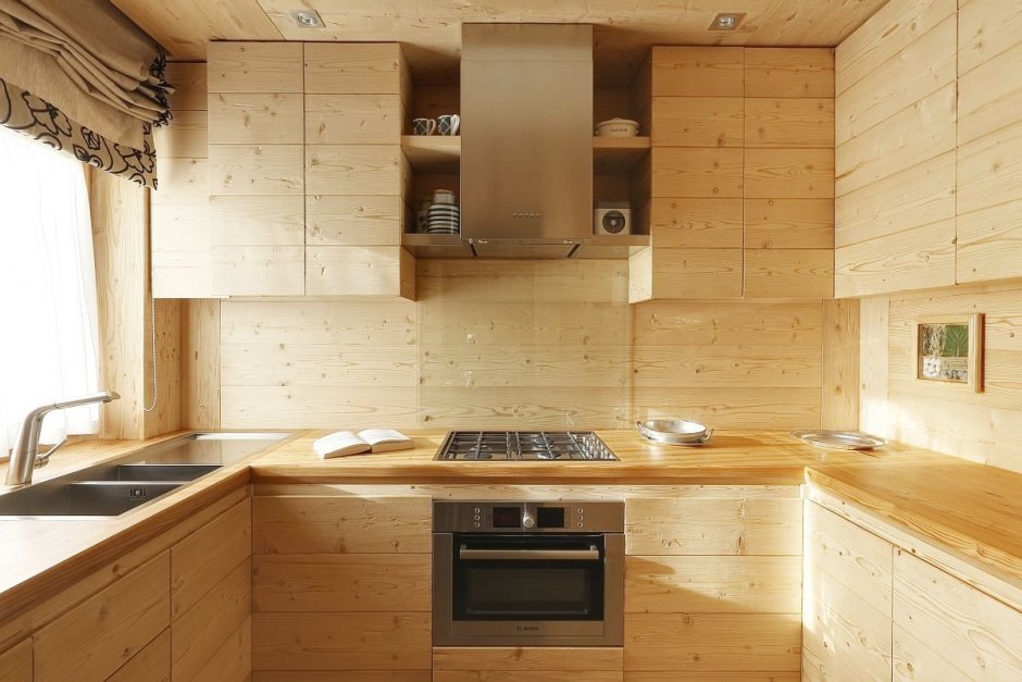 Угловая кухня в деревянном доме с окном