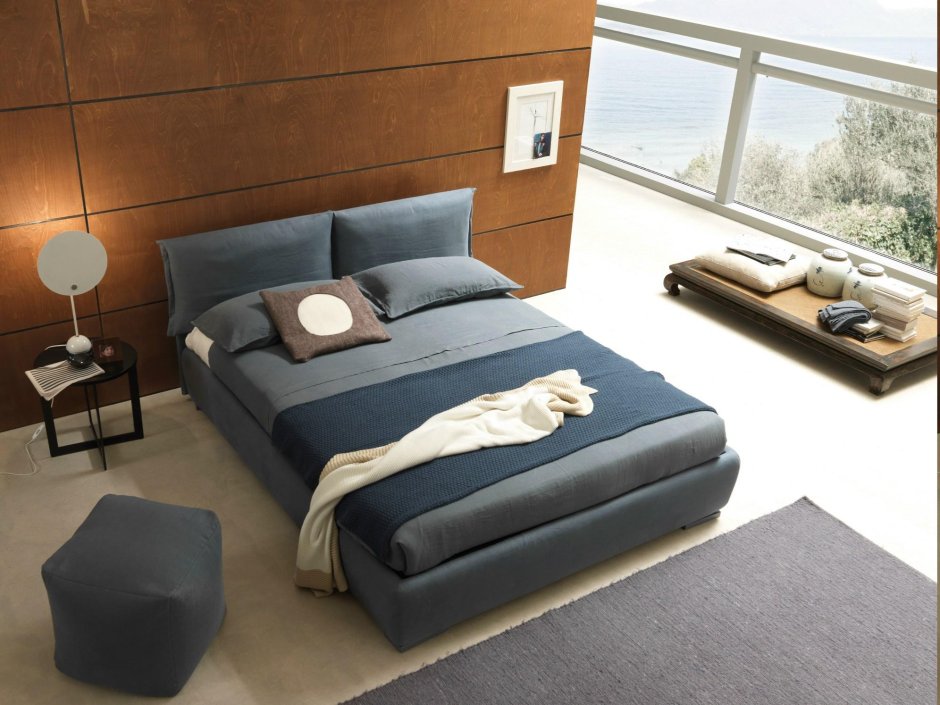 Кровать с мягкими подушками в изголовье