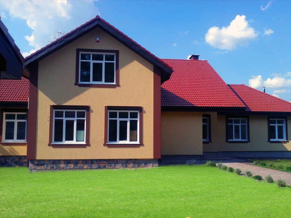 Дом в штукатурке с коричневой крышей